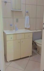 a bathroom with a sink and a toilet at Hospedagem 4Lm in Penha