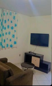 a living room with a couch and a flat screen tv at Hospedagem 4Lm in Penha