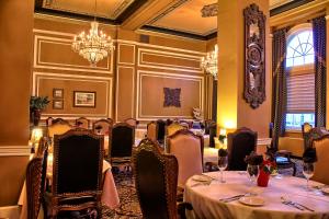 ein Esszimmer mit Tischen und Stühlen und einem Kronleuchter in der Unterkunft Grant Hall Hotel in Moose Jaw
