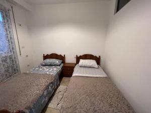 two twin beds in a room with a window at City Apartment in Shkodër