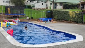 a group of children playing in a swimming pool at Waitomo TOP 10 Holiday Park in Waitomo Caves