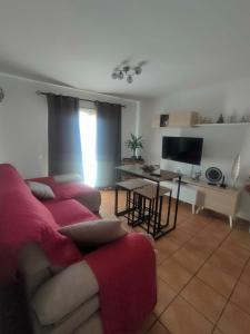 Una sala de estar con un sofá y un televisor. en Casa Fama, en El Paso