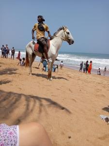 a man riding a horse on the beach at Iroko Plage San Pédro in San-Pédro