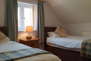 une chambre avec deux lits et une fenêtre dans l'établissement Bwlch Cottage, à Gwaynynog