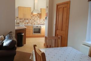 eine Küche mit Tisch und Esszimmer in der Unterkunft Bwlch Cottage in Gwaynynog