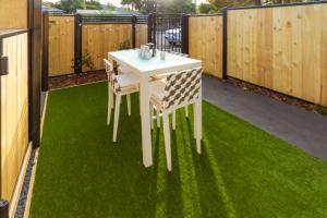 a white table and chairs on a green lawn at CBD Luxury Homes Near Cafes Hagley Park River in Christchurch