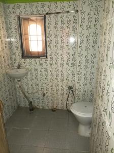 a bathroom with a toilet and a sink at kirtti inn AC double in Guwahati