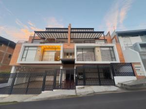 a building with a fence in front of it at Amplio Departamento Familiar en Loja in Loja