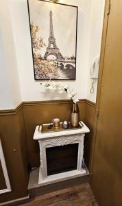 - une cheminée dans une pièce avec une photo de la tour Eiffel dans l'établissement Your hidden charm by Paris, au Kremlin-Bicêtre