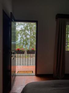 an open door to a balcony with flowers on a fence at Habitación santo antonio in Estrela +4 photos