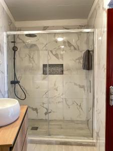 a shower with a glass door in a bathroom at Habitación santo antonio in Estrela