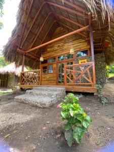 ein Resortgebäude mit einem Strohdach und einigen Pflanzen in der Unterkunft Magic Green Dentro del Parque Tayrona in El Zaino