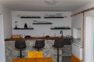 eine Küche mit einer Theke und Hockern in einem Zimmer in der Unterkunft Holiday Home Monte Fabula with Jacuzzi, Sauna and Backyard in Vučinić Selo