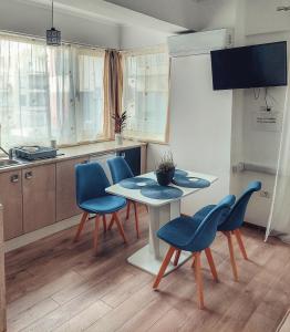 a kitchen with blue chairs and a table and a kitchen at Apartament GabRox in Mamaia Sat/Năvodari