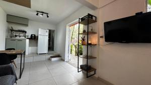 ein Wohnzimmer mit einem Flachbildfernseher an der Wand in der Unterkunft Casa da Floresta in Rio de Janeiro