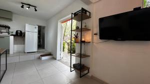 a living room with a flat screen tv on a wall at Casa da Floresta in Rio de Janeiro