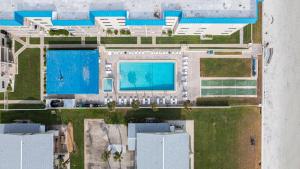 an overhead view of a building with a swimming pool at Serenity Shores Renovated Top Floor Condo w Stunning Ocean Views in New Smyrna Beach