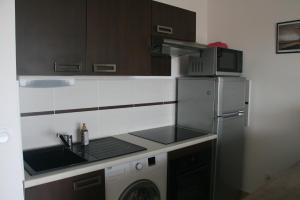 a small kitchen with a sink and a microwave at T2 moderne avec terrasse a 100m de la plage et parking sécurisé 4 PERS MAXI in Saint Pierre La Mer +13 photos