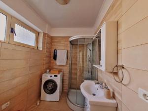 a bathroom with a washing machine and a sink at Apartament GabRox in Mamaia Sat/Năvodari +4 photos