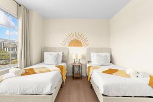 two beds in a room with a window at Remodeled 3B2B Bright House with a King Suite in Sacramento