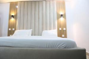 ein Schlafzimmer mit einem großen Bett mit zwei Lampen darauf in der Unterkunft Events & Suites in Abuja