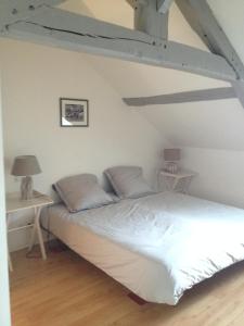 a bedroom with a white bed with two tables at Charmante Maison De Pêcheur in Honfleur
