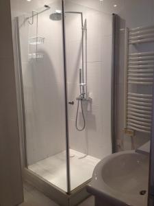 a shower with a glass door next to a sink at Charmante Maison De Pêcheur in Honfleur