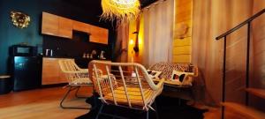 a room with chairs and a table and a kitchen at Appartement SPA Safari in Solesmes
