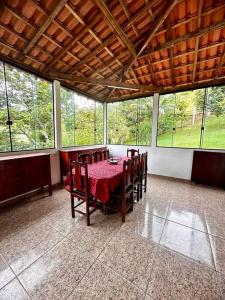ein Esszimmer mit Tisch und Stühlen und Fenstern in der Unterkunft Casa no Sitio em São José do Barreiro in São José do Barreiro