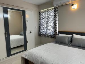a bedroom with a large mirror and a bed at Aami dhivahi guest house 03 in Trivandrum