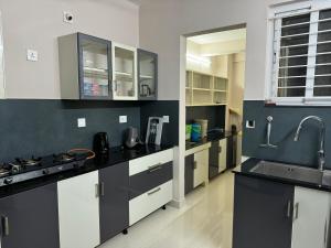 a kitchen with black and white cabinets and a sink at Aami dhivahi guest house 03 in Trivandrum