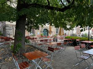 a group of tables and chairs under a tree at Gasthof Mayd in Erlangen