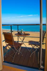 a balcony with a table and chairs on the beach at The Sands in Scarborough