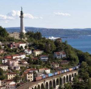 a train traveling over a bridge near a lighthouse at Casa de Mama in Trieste