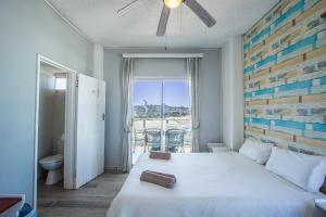a bedroom with a large white bed and a balcony at Seagull 401 in Margate