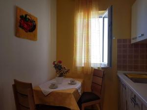 a small table and chairs in a kitchen with a window at Apartment Desa in Bol