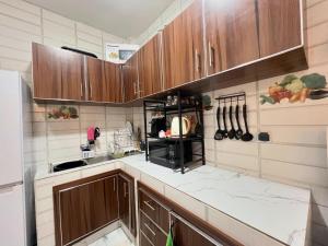 uma cozinha com armários de madeira e bancadas brancas em chambre white sans télé ngor almadie em Ngor