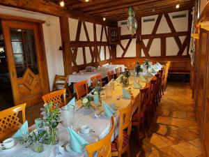 a long dining room with white tables and chairs at Gasthof Mayd in Erlangen