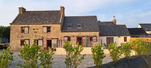 Cette ancienne maison en briques est dotée de portes et de fenêtres rouges. dans l'établissement Nouveau Maison campagne Plouescat - TyPra, à Plouescat