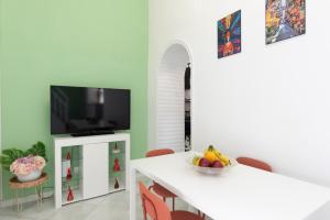 a dining room with a white table and a tv at Seventeen Home in Naples +58 photos