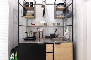 a small kitchen with a sink and shelves at Seventeen Home in Naples