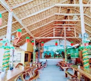 a dining room with wooden tables and chairs at Blue Lagoon Inn and Restaurant, Pagudpud in Mabubua