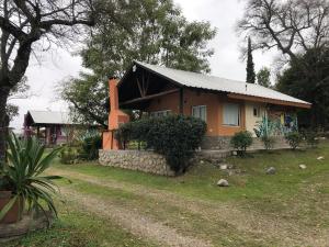 a small house with a stone wall in front of it at Casitas de Campo Wara kusi in Vaqueros
