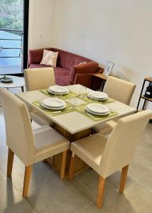 Una mesa de comedor con sillas y un sofá. en A dos cuadras del Paseo la Galería, en Asunción