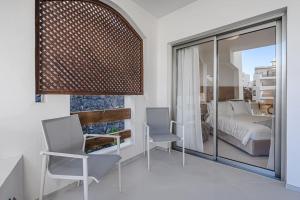 ein Schlafzimmer mit einem Bett und zwei Stühlen und einem Fenster in der Unterkunft Luxury 2 bedrooms apartment in Palm-Mar, Tenerife in Palm-mar