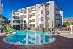 ein großes weißes Wohnhaus mit einem Swimmingpool in der Unterkunft Luxury 2 bedrooms apartment in Palm-Mar, Tenerife in Palm-mar