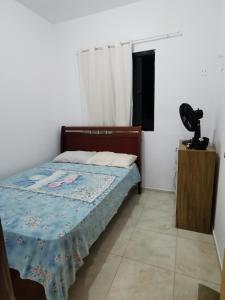a bedroom with a bed with a blue quilt on it at Rancho do Poeta - Chalé Cajueiro in Lagoa Nova