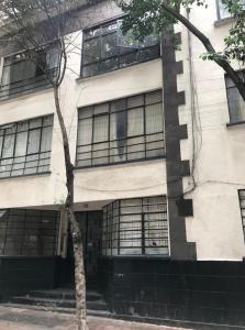 メキシコシティにあるHabitación en departamento a una cuadra de REFORMA Centro Históricoの窓と木が目の前にある建物
