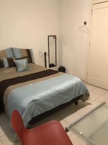 メキシコシティにあるHabitación en departamento a una cuadra de REFORMA Centro Históricoのベッドと赤い椅子のある寝室 +6枚の写真