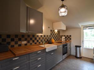 a kitchen with gray cabinets and a sink and a window at Gutshofblick L in Hanshagen +5 photos